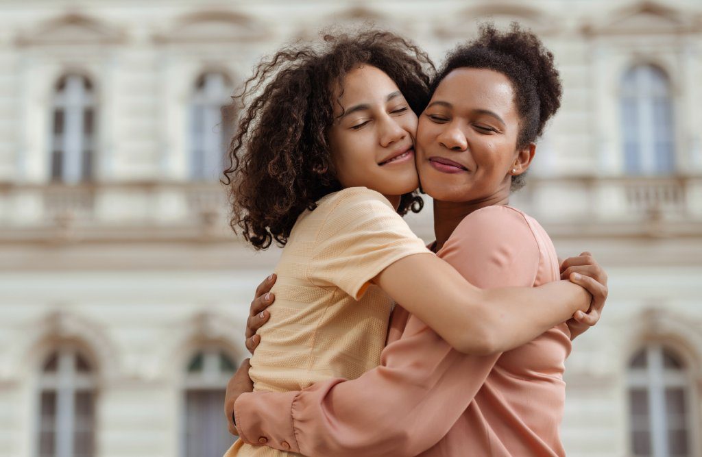 Mother and Teen Son Sharing a Warm Embrace Outdoors