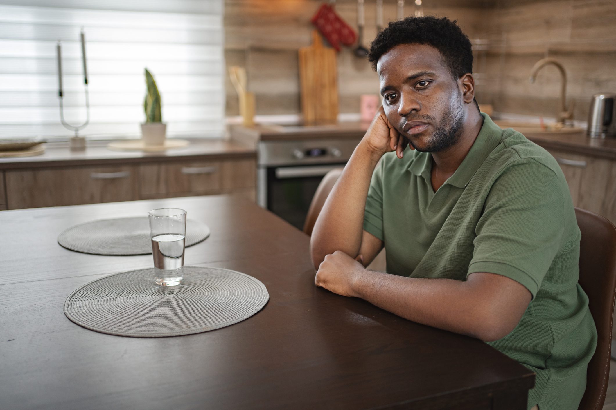 Tattooed arm covering face in stress